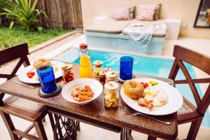 ディアニ・ビーチにあるMonkey Suitesの朝食の食べ物と飲み物の皿が置かれたテーブル