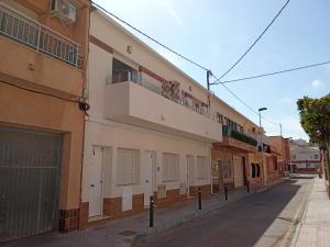 ein Gebäude mit einem Balkon an der Straßenseite in der Unterkunft San Pedro del Pinatar Casa Sweeney in Lo Pagán