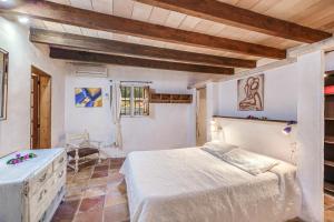 a bedroom with a bed in a room with wooden ceilings at Son Del Rio Nou in Pollença +19 photos