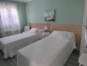 two beds in a room with two tables and a window at Alojamiento a 25km de Madrid apta para mascotas cerca de zonas de ocio in Navalcarnero