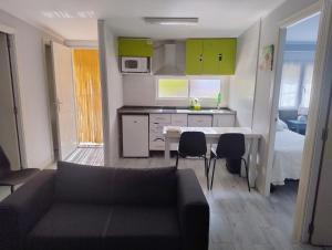 a living room with a couch and a table and a kitchen at Alojamiento a 25km de Madrid apta para mascotas cerca de zonas de ocio in Navalcarnero