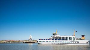 a ferry boat is docked in the water at Hotel Atlantic Juist in Juist