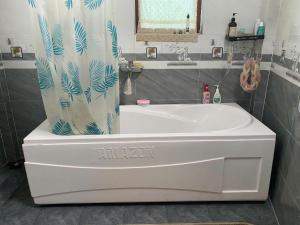 Làng XaにあるHa Giang Uphill Coffee Farmstayのバスルーム(白いバスタブ、シャワーカーテン付)