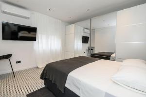 una camera da letto con un letto bianco e una televisione di New luxury apartment Adriatic a Spalato (Split)