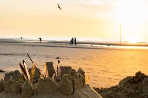 a sand castle on the beach with people in the background at Hotel Atlantic Juist in Juist