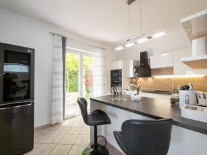 a kitchen with a black counter and chairs in it at Elegant Apartments BOP in Portorož