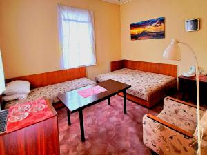 a small room with two beds and a table at Basanavičiaus kampelis in Palanga