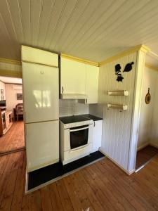 a kitchen with a stove and a refrigerator at Horse Farm Cottage in Örebro +23 photos