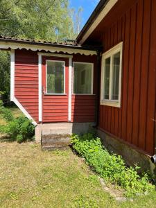 a red house with a door and a window at Horse Farm Cottage in Örebro