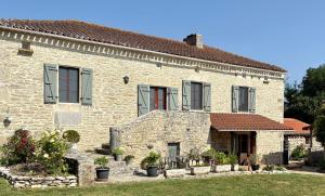 an old stone house with red doors and windows at La Gaillardenque Gîtes - Farmhouse and Gîte in Floressas