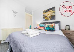 a bedroom with a large bed with white sheets and pillows at Broomfield Apartment by Klass Living Airdrie in Airdrie