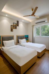 グルガオンにあるFlxHo Cyber One - Hotel And Banquet- DLF Cyber Cityの窓が2つある部屋にベッドが2つある +115枚の写真