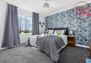 a bedroom with a bed and a blue wall at Coats Street Apartment by Klass Living Coatbridge in Coatbridge