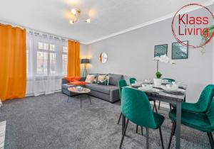 a living room with a table and green chairs at Coats Street Apartment by Klass Living Coatbridge in Coatbridge