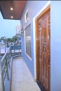 a wooden door on a building with a balcony at De Classico Residency in Ayodhya