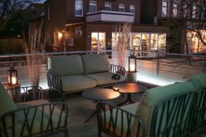 a patio with a couch and tables and lights at Hotel Atlantic Juist in Juist