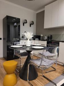 a dining room with a table and chairs and a kitchen at Апартаменты Luxe в центре города in Kokshetau