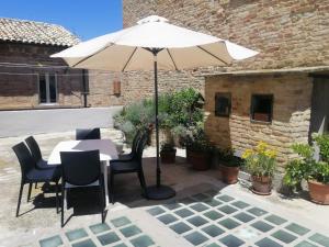 a table and chairs under an umbrella on a patio at Casa D'Angelo in Cossignano