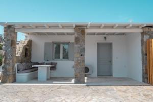 a pavilion with a table and a couch on a patio at Villa & Suite Elia Mykonos in Mikonos