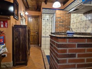 a kitchen with a sink and a brick wall at 211A La Chalana Bonito Estudio en Tazones in Tazones +10 photos