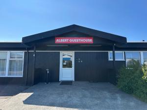 a black building with a sign that reads alert guest house at ALBERT Guesthouse in Hvammstangi