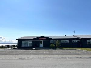 a building with a parking lot next to the ocean at ALBERT Guesthouse in Hvammstangi +48 photos