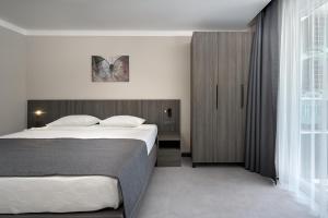 Postel nebo postele na pokoji v ubytování Kaila Krizantem Hotel