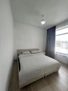 a bed in a bedroom with a large window at Yssyk-kul Palm in Chok-Tal