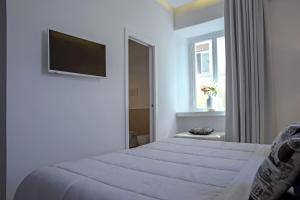 a bedroom with a bed and a flat screen tv at Starhost - PETIT B&B in Salerno