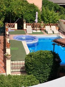 a swimming pool in a yard with chairs and trees at Casa Rural Valdevilano in La Roca de la Sierra