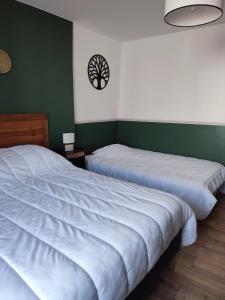 two beds in a room with green and white walls at Maison de vacances ile d'Oléron 4 pers à St Denis proche plage in Saint-Denis-dʼOléron