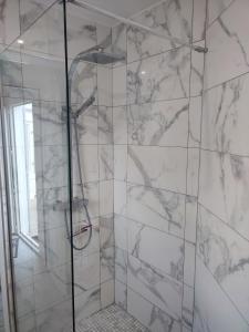 a bathroom with a shower with marble walls at Maison de vacances ile d'Oléron 4 pers à St Denis proche plage in Saint-Denis-dʼOléron +6 photos