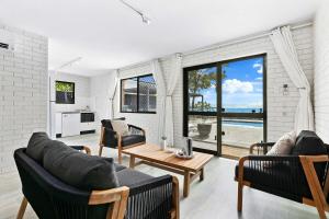 a living room with two couches and a table at Salt & Stone Villa on the beach - Villa 2 in Burrum Heads