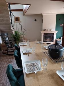 a room with a table with wine glasses and a fireplace at Gîte L'instant Ressource pour rassemblement familial ou entre amis au coeur de la Puisaye Forterre in Villiers-Saint-Benoît