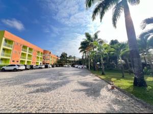 a cobblestone street with palm trees and a building at Hotel Absolar in Alagoinhas