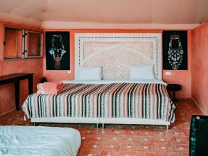 1 Schlafzimmer mit 2 Betten und orangefarbenen Wänden in der Unterkunft The Original Camp in Aït Daoud + 53 Fotos