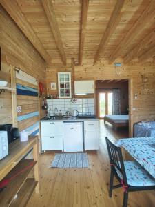 a kitchen in a log cabin with a sink and a table at O Gato do Mar in Viana do Castelo