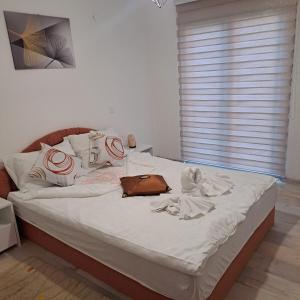 a bed with white sheets and a purse on it at Oaza mira BK in Bosanska Krupa +13 photos