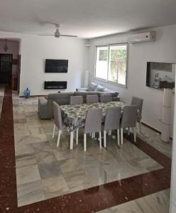 Una sala de estar con una mesa y sillas y un sofá. en Spacious Garden Villa, private pool, huge grounds with orange trees, en Dos Hermanas