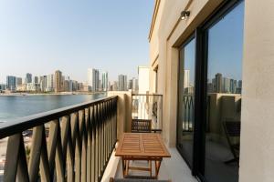 balcón con banco y vistas a la ciudad en Stunning 2 Bed in Cyan Beach Residence, en Sharjah