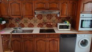 a kitchen with a sink and a microwave at casa 1, 2 o 3 habitaciones - HOSTAL CAMELOT in Fabero