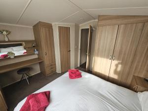 a bedroom with a bed with a red bag on it at Punchbowl Caravan Park in Penrith