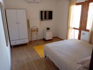 a bedroom with a bed and a white cabinet at Benjamin Room in Olbia