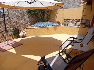 a patio with two chairs and an umbrella at Benjamin Room in Olbia