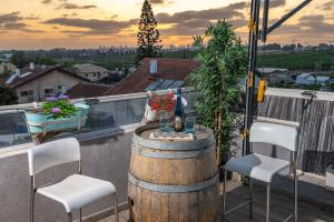 Kefar Ziwנוף לפרדסים - דירה מהממת עם 2 חדרי שינה ומרפסת גג的阳台上的桌子和椅子，还有桶