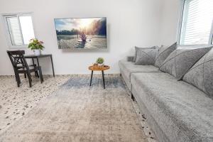 a living room with a couch and a table at נוף לפרדסים תל מונד - דירה מהממת עם 2 חדרי שינה ומרפסת גג in Kefar Ziw