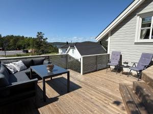 patio con divano e tavolo sul ponte di Trivelig Feriehus Leilighet, Risør, Sørlandet med tilgang til båt a Risør