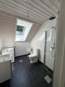 un bagno con un water, un lavandino e una finestra di Trivelig Feriehus Leilighet, Risør, Sørlandet med tilgang til båt a Risør Altre 29 foto