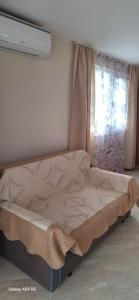 a bed sitting in a room with a window at Къща за гости ЕДЕЛВАЙС in Chernomorets