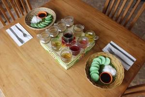 a wooden table with three baskets of food and drinks at nyoman sekumpul house in Sudaji